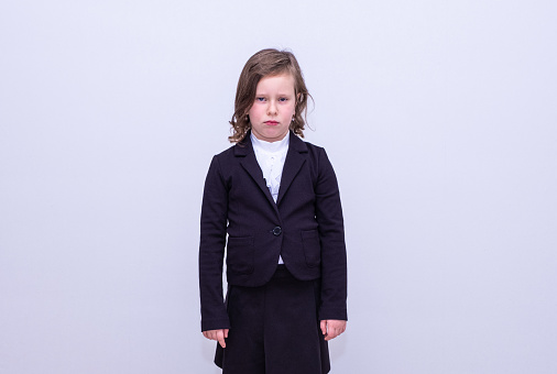 A child in a school uniform with an emotional facial expression.