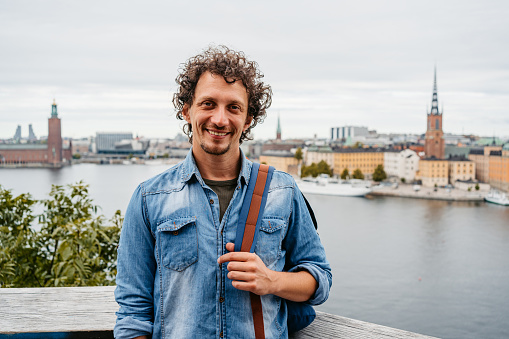 Portrait of a handsome young man at the high viewpoint in Stockholm, Sweden.