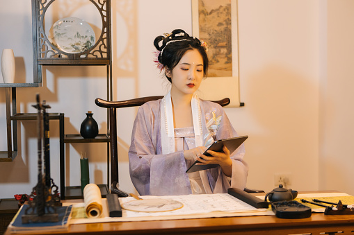 Asian Hanfu beauties use tablets at home