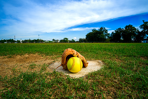 Softball and glove on Homepage and View of a Softball Field from Home Plate