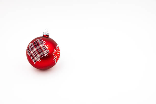 A distinctive red Christmas bauble isolated against a white background in the studio