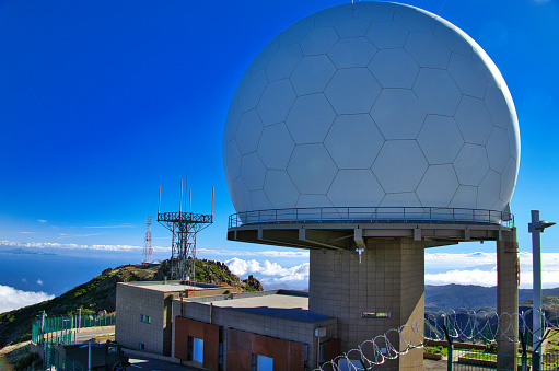 Pico do Arieiro, Madeira - Technology in the natural setting of a mountain peak - Radar station, aerials, communications tower and antennae with clouds below, viewed from the peak of Pico do Arieiro