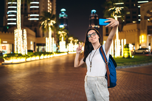 Beautiful young woman taking selfies in Pearl-Qatar in Doha, Qatar.