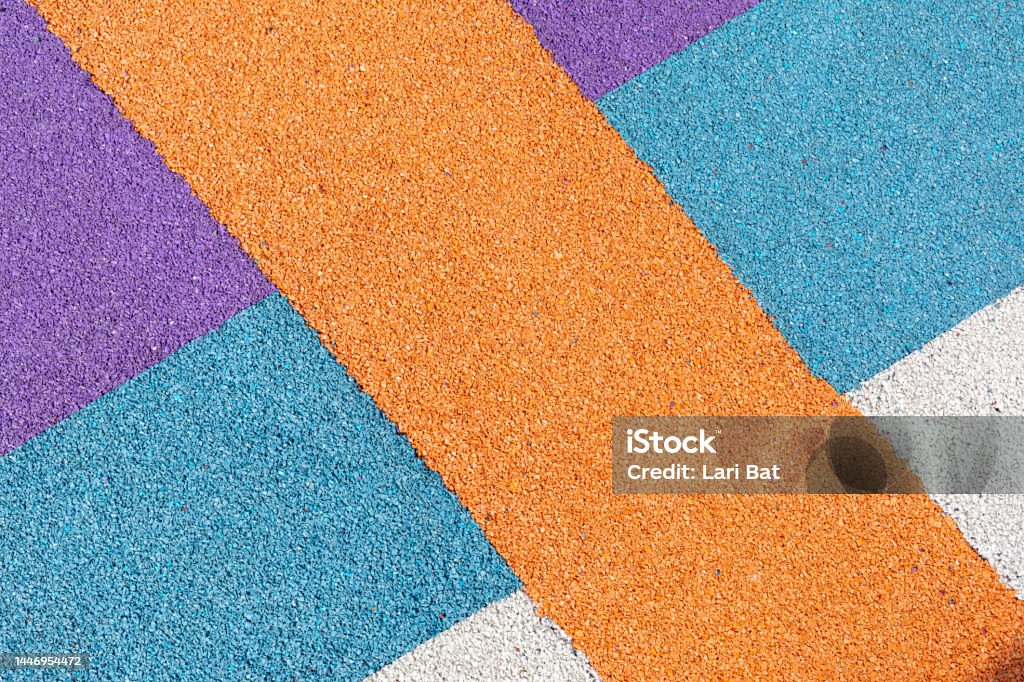 Special rubber coating for playground or sports activity. Junction of multicolored pieces of floor covering made of recycled materials. Padded floor covering with rubber granules. Special rubber coating for the playground or sports activity. Junction of multicolored pieces of floor covering made of recycled materials. Padded floor covering with rubber granules. Playground Stock Photo