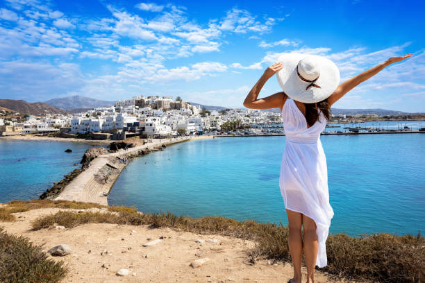 a happy tourist woman in a summer dress looks at the town of naxos island - sky sea town looking at view imagens e fotografias de stock