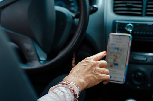 Woman's hand with map on smartphone inside the car
