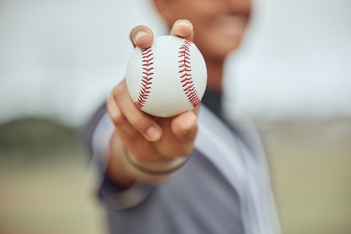 Athlete with baseball in hand, man holding ball on outdoor sports field or pitch in New York stadium. American baseball player's catch, exercise fitness with homerun or retro sport bokeh background