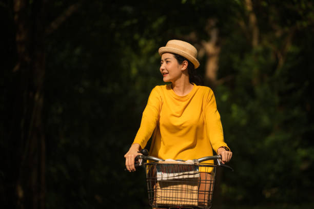 공원에서 자전거를 타는 여자 - mental health women asian ethnicity bicycle 뉴스 사진 이미지