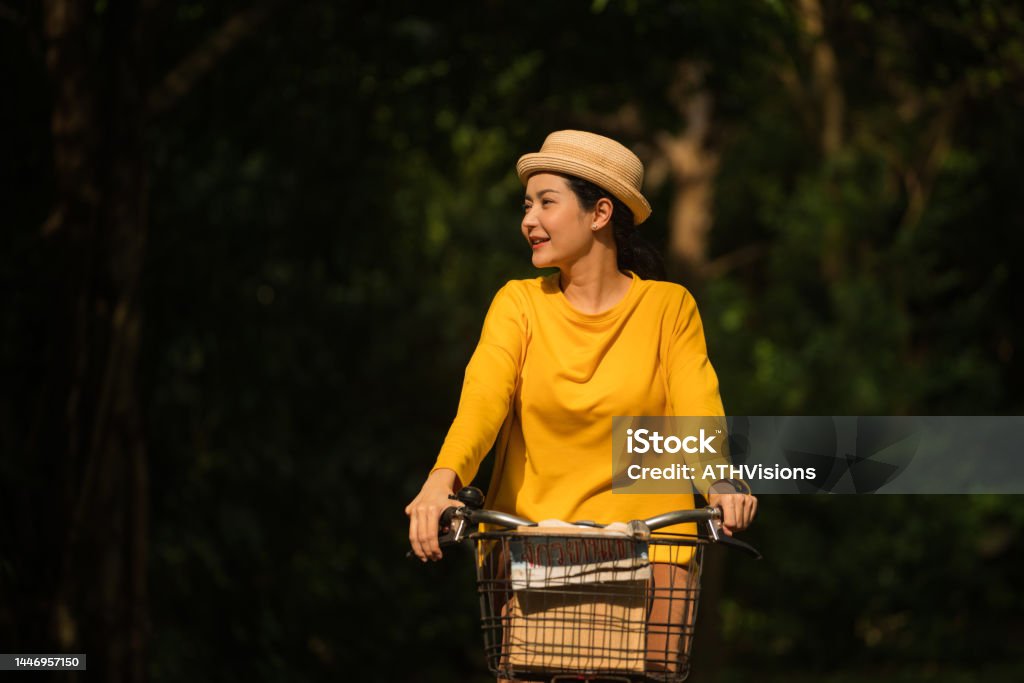 Woman riding a bicycle in the park Woman riding a bicycle in the park. Environmental Wellbeing Active Lifestyle Stock Photo