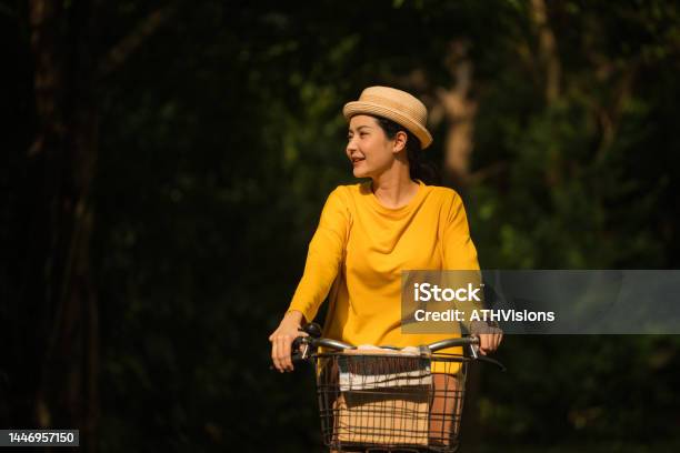 Woman Riding A Bicycle In The Park Stock Photo - Download Image Now - Active Lifestyle, Adult, Adults Only