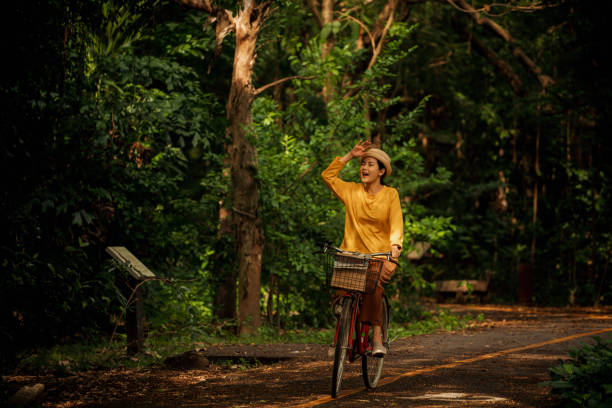 주말에 공원에서 자전거를 타는 어른 여성 간단한 즐거움 - mental health women asian ethnicity bicycle 뉴스 사진 이미지