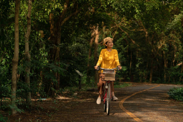 주말에 공원에서 자전거를 타는 어른 여성 간단한 즐거움 - mental health women asian ethnicity bicycle 뉴스 사진 이미지