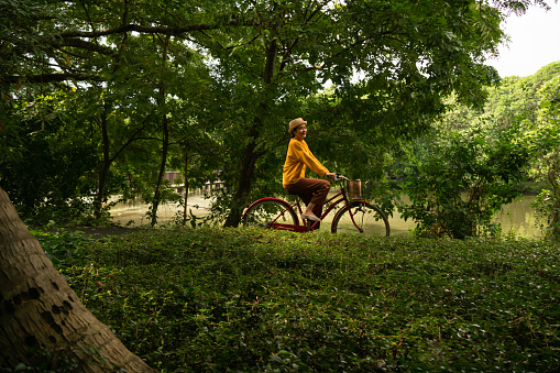 Woman riding a bicycle in the park. Environmental Wellbeing