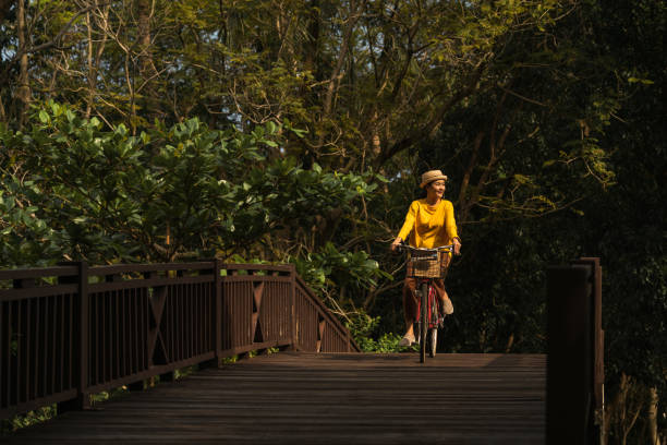 kobieta jazda na rowerze w parku - mental health women asian ethnicity bicycle zdjęcia i obrazy z banku zdjęć