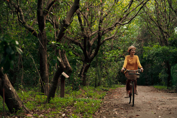 femme, faire du vélo dans le parc - mental health women asian ethnicity bicycle photos et images de collection