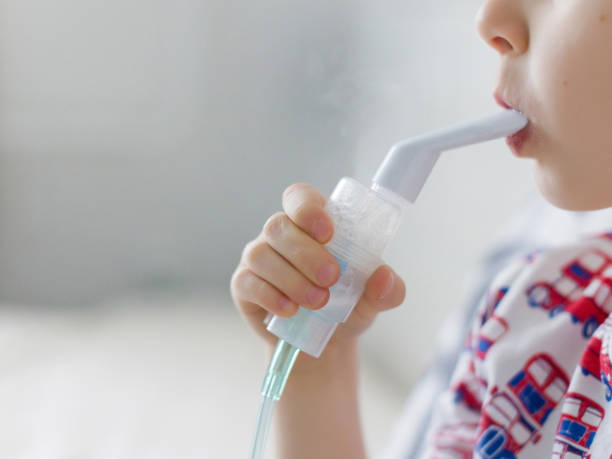 istock Caucasian boy making inhalation with nebulizer 1446959728