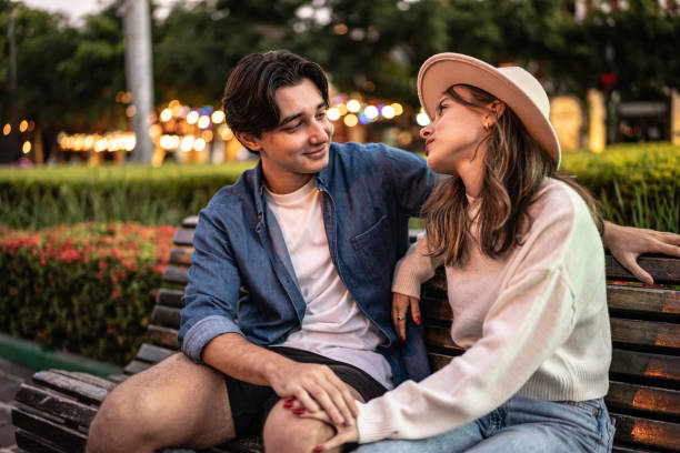 istock Young couple talking on a bench outdoors 1446961226