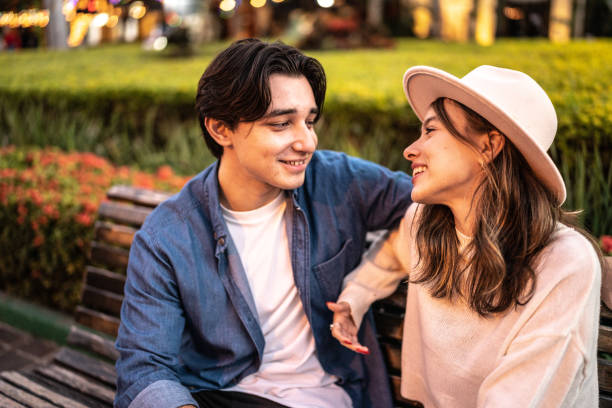 istock Young couple talking on a bench outdoors 1446961256
