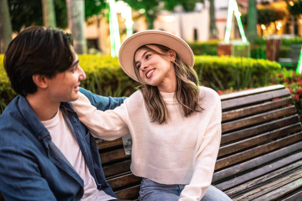 istock Young couple talking on a bench outdoors 1446961271