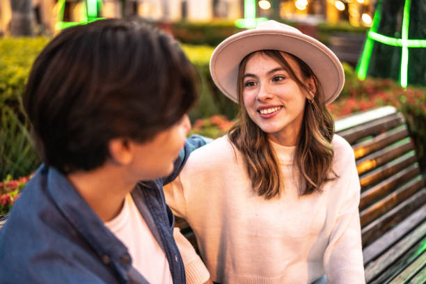 istock Young couple talking on a bench outdoors 1446961287