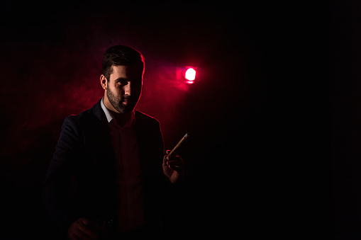 Photo of standing man and pink light on the background. Concept of man in suit.