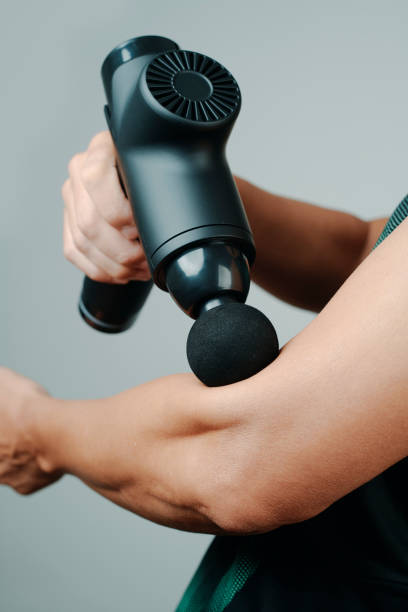 istock man in sportwear using a massage gun on his arm 1446961763