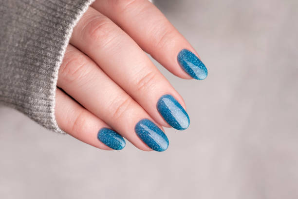 istock Female hand with blue glitter nails 1446961788