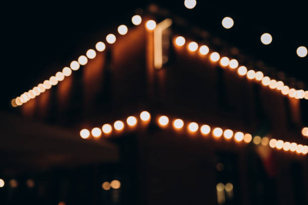 istock Decorative outdoor string lights at night time, Defocused Background, night city life backdrop, party time with Yellow bokeh balls 1446963585