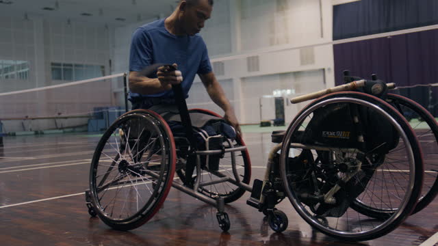 Asian male sits in a competitive wheelchair  preparation  before a match.
