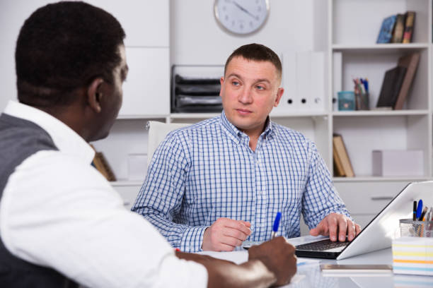 istock Businessmen in office clothes filling up documents indoor 1446965792