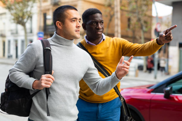 istock Two men tourists point finger sightseeing at street 1446965793