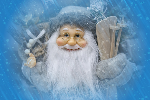 Bearded Christmas wizard with skis and gifts, Santa with gifts. The atmosphere of festive mood of anticipation. Souvenir, festive decor and present for New Year and Christmas.