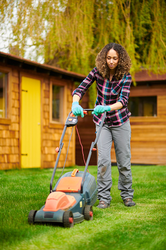 female gardener mowing the lawn