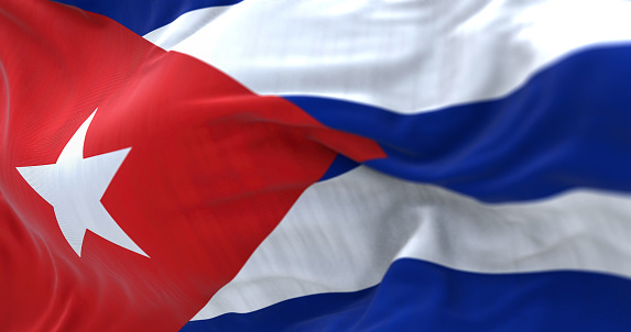 Close-up view of the Cuba national flag waving in the wind. The Republic of Cuba is an island state in Central America. Fabric textured background. Selective focus.