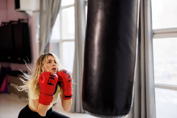 istock Young female boxer training with punching bag in the gym 1446968992