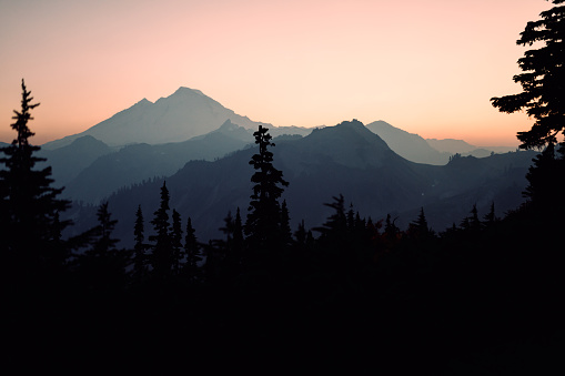 A beautiful Autumn day at dusk in Mount Baker area, Washington state, USA.  A thick haze brings vibrant color to the sunlight, and layers of contrast to the silhouettes of the scene.    A wonderful place of nature to explore and discover.
