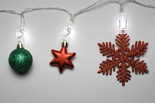 Christmas lights with Christmas ornaments hanging on the wall