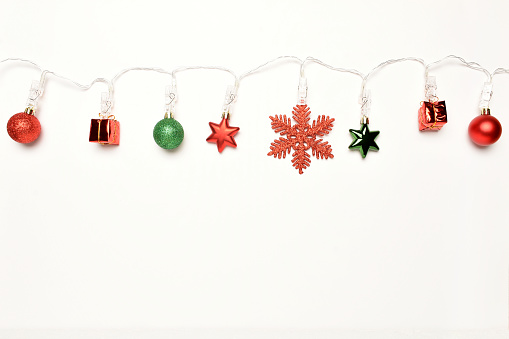 Christmas lights with Christmas ornaments on the white background with copy space