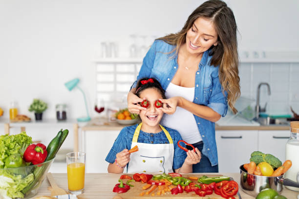 istock Mother and daughter cooking together in a kitchen 1446976893