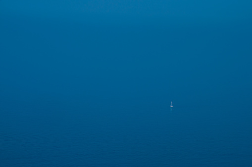 A sailboat in the majestic blue sea on the Mediterranean Sea