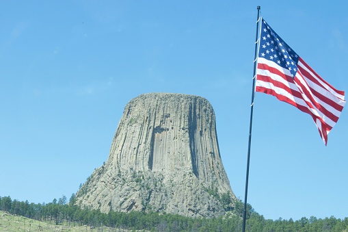 Devil’s Tower with a US Flag shown in foreground