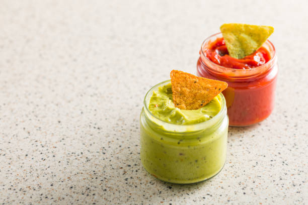 Tex-mex food: salsa sauce, guacamole and pico de gallo. Nacho chips complete the composition. High resolution 42Mp studio digital capture taken with Sony A7rII and Sony FE 90mm f2.8 macro G OSS lens