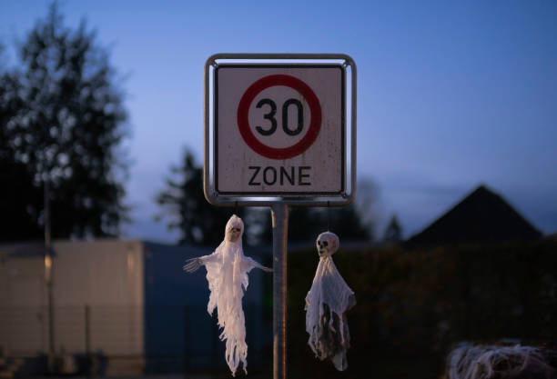 istock Halloween decorations. two dummy ghosts hung on the speed sign. 1446986133