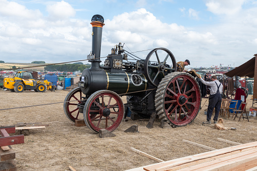Tarrant Hinton.Dorset.United Kingdom.August 25th 2022.A 1920 Ruston and Hornsby general purpose traction engine called Oliver is powering a circular saw at the Great Dorset Steam Fair
