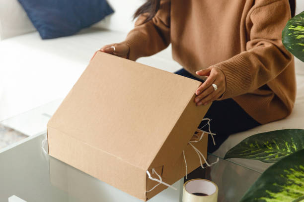 istock Young woman unpacking or packing the package with present 1446993095