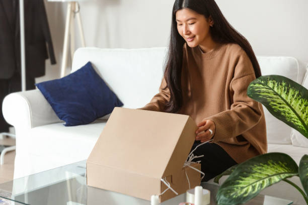 istock Young woman unpacking or packing the package with present 1446993147