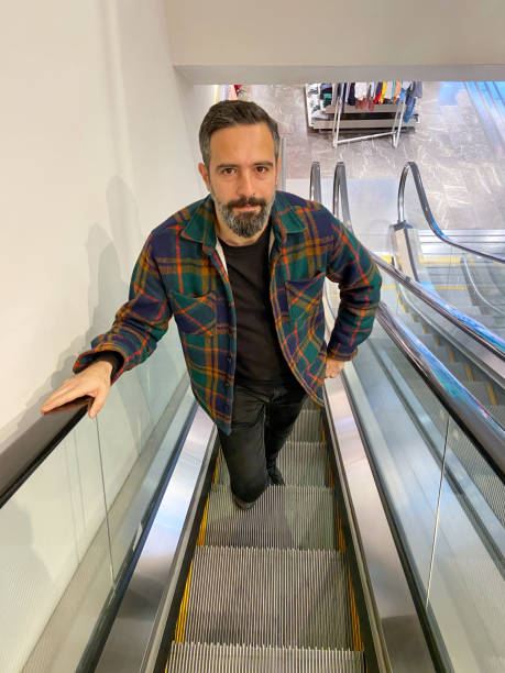 istock Man on escalator in the shopping mall 1446993623