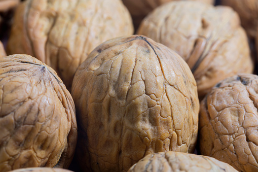 macro close up view of a handful of walnuts. Natural walnuts on the table, Pattern of ripe eating walnuts. drupe seed Antioxidant dried fruit.