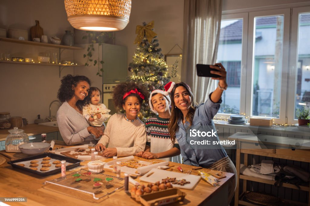 Christmas baking Female gay couple with kids having fun for Christmas at home. They are baking cookies in kitchen. Christmas Stock Photo
