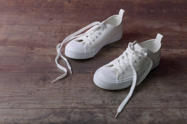 istock White sneakers on a old textured wood background 1447002113